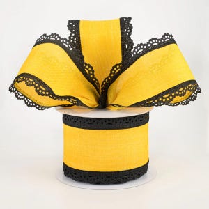 May include: A spool of yellow ribbon with black lace trim. The ribbon is a bright yellow color, and the edges are trimmed with a delicate black lace. The ribbon is rolled on a white spool, ready for use in crafts or decorations.