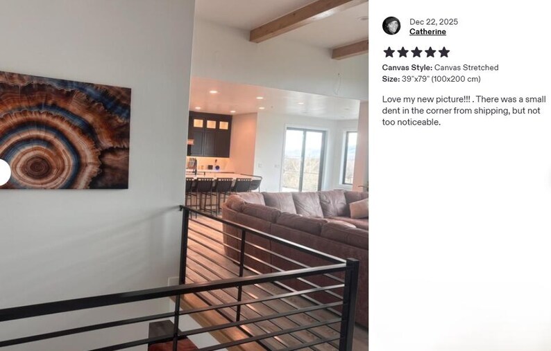 a modern living room with a large abstract painting on the wall, a comfortable couch, and a kitchen visible in the background.
