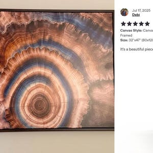 The image is a large framed artwork depicting a spiral pattern in shades of brown and orange. The artwork is displayed on a wall, and there is a review rating and description provided next to it.