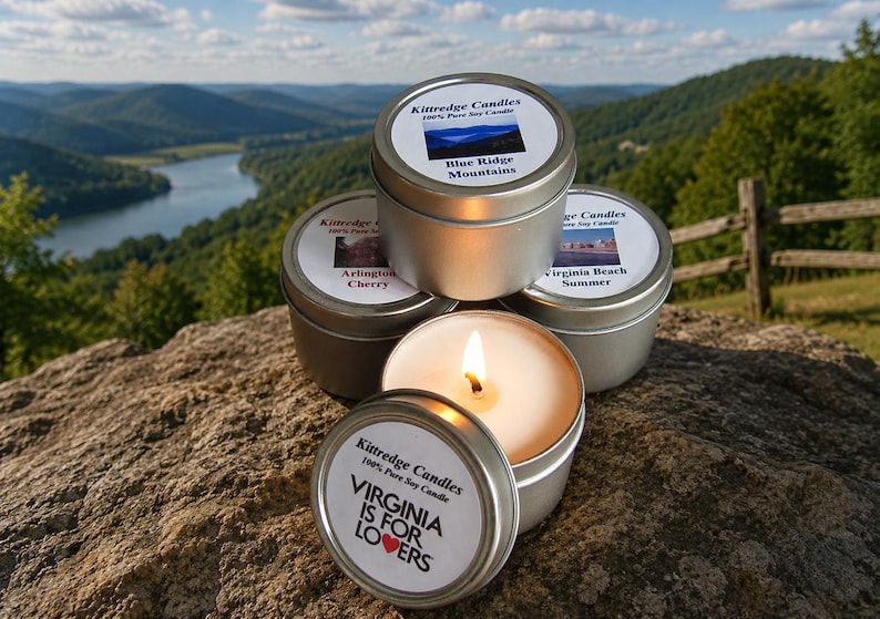 May include: Four round silver metal tins containing soy candles. Labels feature text including Kittredge Candles, 100% Pure Soy Candle, Blue Ridge Mountains, Arlington Cherry, Virginia Beach Summer, and Virginia Is For Lovers with a red heart icon.