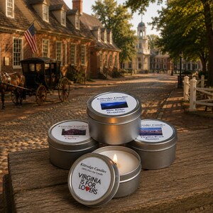 May include: Four round silver metal candle tins with white labels. Three tins are closed, and one is open with a lit candle. Labels feature text including Kittredge Candles, Blue Ridge Mountains, Arlington Cherry, Virginia Beach Summer, and Virginia Is For Lovers.