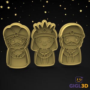 Może przedstawiać: Trzy złote wykrawacze do ciastek w kształcie Trzech Króli, każdy z odrębnym wzorem. Wykrawacze są umieszczone na czarnym tle z małymi złotymi gwiazdkami.