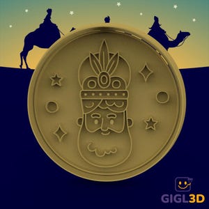 Puede incluir: Un cortador de galletas de color beige con una ilustración detallada de la cara de un rey con corona y barba. El diseño circular incluye estrellas y diamantes alrededor de la cara del rey. Siluetas de personas montando camellos en el fondo.