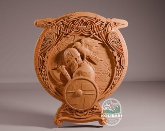 Puede incluir: Una placa de pared de madera con un diseño tallado de un guerrero vikingo sosteniendo un escudo y un hacha. Dos cuervos están tallados a cada lado del guerrero, y el diseño está rodeado por un borde de nudo celta.