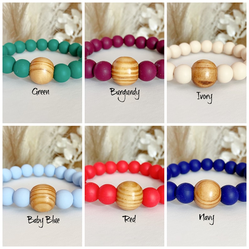 May include: Six silicone bracelets with a wooden bead in the center. The bracelets are in the colors green, burgundy, ivory, baby blue, red, and navy.