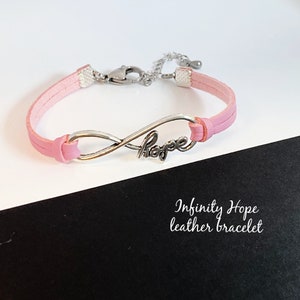 May include: Pink leather bracelet with an infinity symbol charm that says "Hope".