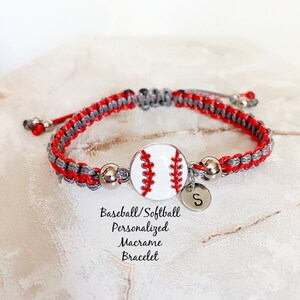 May include: Red and gray macrame bracelet with a white baseball charm and a silver charm with the letter "S". Baseball/Softball Personalized Macrame Bracelet.
