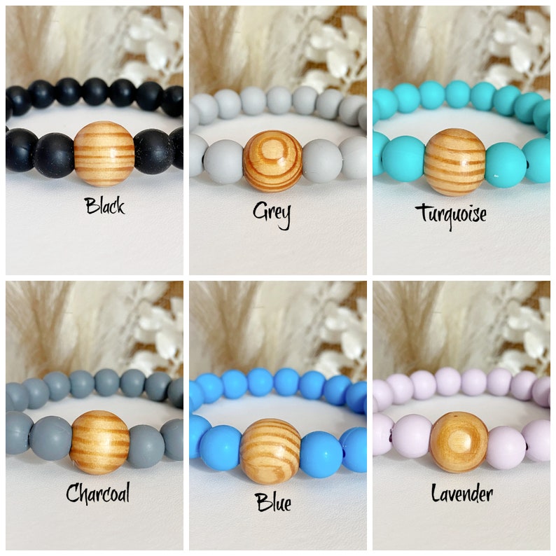 May include: Six silicone bracelets with a wooden bead in the center. The bracelets are in the colors black, grey, turquoise, charcoal, blue, and lavender.