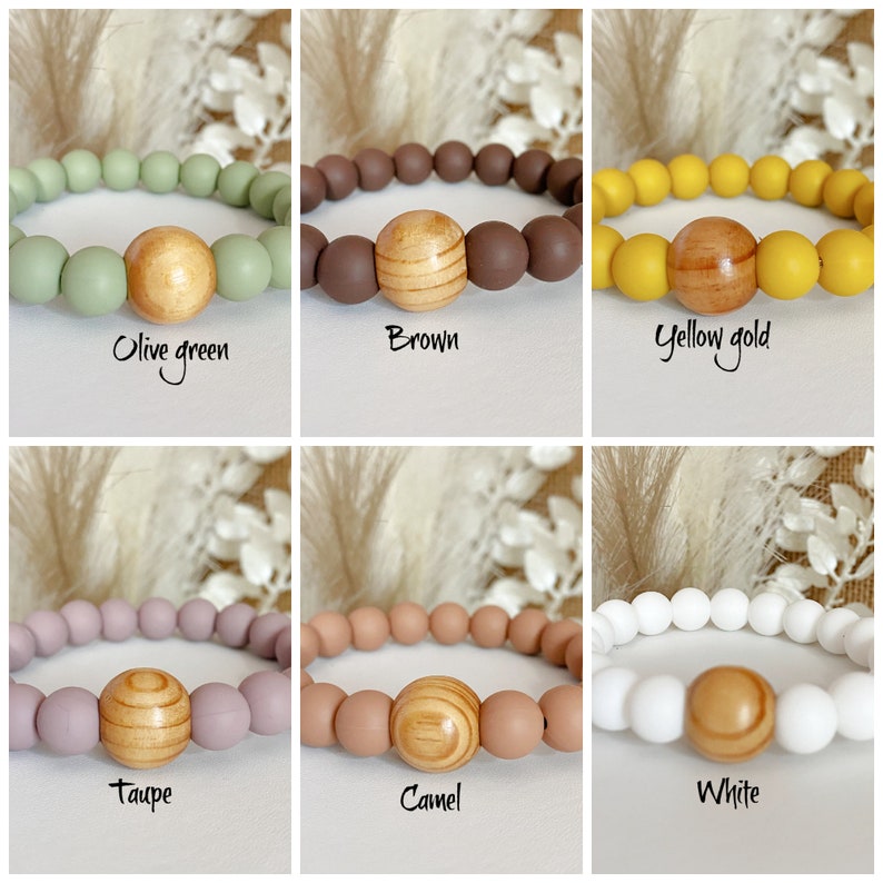 May include: Six silicone bracelets with a wooden bead in the center. The bracelets are in the colors olive green, brown, yellow gold, taupe, camel, and white.
