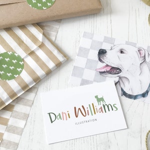 May include: A business card with the text "Dani Williams Illustration" in colorful, handwritten font. A green silhouette of a dog is in the top right corner.