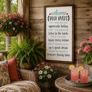 May include: A rectangular wooden wall sign with a white background and a dark brown frame. The sign features black and teal text that reads: welcome DECK RULES, SIT AND RELAX, appreciate today, FEEL THE BREEZE, listen to the birds, TALK TO GOD, enjoy every season, REST YOUR SOUL, sip a good drink, MAKE MEMORIES, treasure family time.