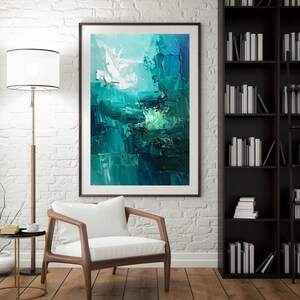 May include: Abstract art print in a dark wooden frame. The artwork features a textured, impasto style with shades of teal, turquoise, and white. The painting is displayed in a room with a white brick wall, a wooden chair, and a bookshelf.