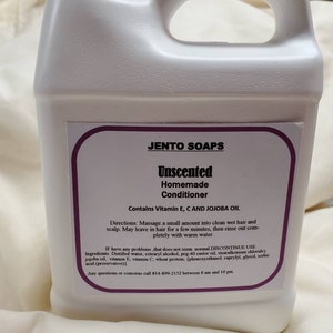 May include: A white plastic jug with a purple label that reads "JENTO SOAPS Unscented Homemade Conditioner Contains Vitamin E, C AND JOJOBA OIL". The label also includes directions for use and a list of ingredients.
