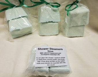 May include: Three packages of shower steamers for sinus relief. Each package contains two white shower steamers with green ribbon tied around them. The text on the front of the package reads "Shower Steamers Sinus With natural Peppermint and Eucalyptus Essential oils. To use place the shower bomb in shower away from running water and drain. Take a few deep breaths as the tablet melts and releases its essential oils into the steam."