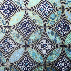 May include: A blue and gold patterned paper with a repeating geometric design. The pattern features circles, diamonds, and floral motifs.