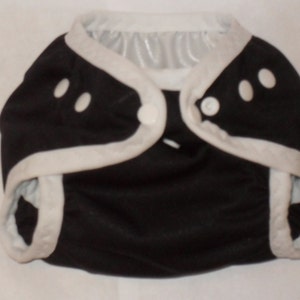 May include: Black cloth diaper with white trim and snap closures.