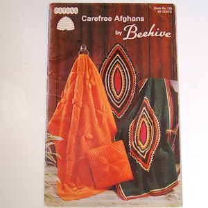 May include: A vintage crochet pattern book titled "Carefree Afghans by Beehive" with a picture of three crocheted afghans in orange, green, and red.