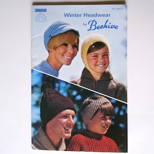 May include: A vintage knitting pattern booklet for winter headwear by Beehive. The cover features four people wearing different knitted hats and ear warmers. The text on the cover reads "Winter Headwear by Beehive" and "65 cents".