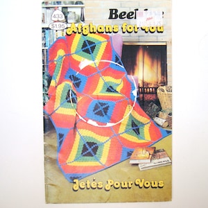 May include: A vintage book cover titled "Afghans for You" featuring a colorful, geometric crochet afghan. The afghan design includes red, yellow, blue, and green squares. The cover also has the text "Jetés Pour Vous".