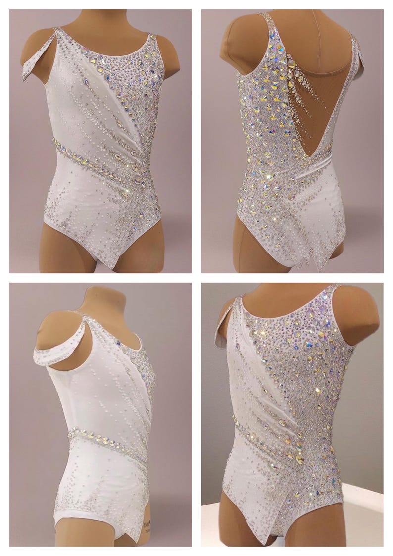 May include: White leotard with sparkling crystal embellishments. The leotard features a unique asymmetrical design with a diagonal pattern of crystals and a low back. Perfect for dance or gymnastics performances.