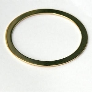 Pu&ograve; includere: Un anello di metallo color oro, di forma rotonda, con una superficie liscia e lucida.