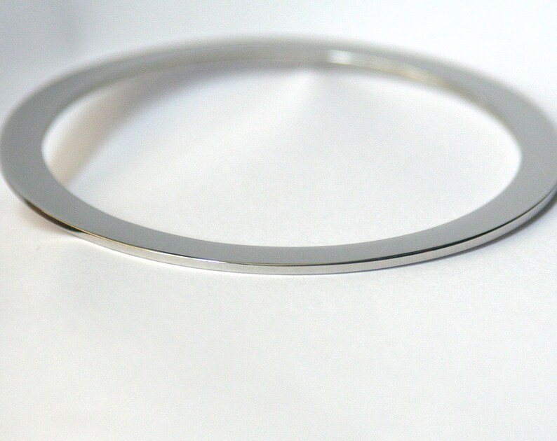 Pu&ograve; includere: Un anello di metallo argentato con una finitura liscia e lucida.