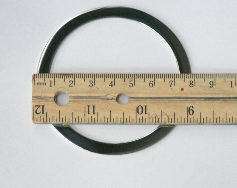 Pu&ograve; includere: Un anello di metallo argentato con un diametro di circa 18 cm, misurato con un righello.