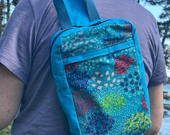Bolso bandolera Sandhill de lona encerada azul brillante con bolsillo frontal floral azul.