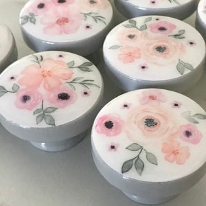 Peut inclure: Ensemble de boutons de tiroir floraux gris et blancs avec des fleurs roses en aquarelle.