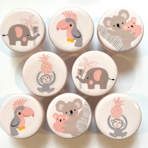 Peut inclure: Ensemble de 8 boutons en céramique rose et gris représentant différents animaux de la jungle, notamment un toucan, un éléphant, un singe, un koala et un ananas. Les boutons sont parfaits pour ajouter une touche de fantaisie à n'importe quelle pièce.