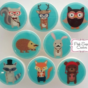 Peut inclure: Ensemble de huit carreaux ronds en céramique turquoise et blanc avec des images de différents animaux portant des lunettes et des accessoires. Les animaux comprennent un écureuil, un cerf, un hibou, un hérisson, un lapin, un renard, un raton laveur et un ours.