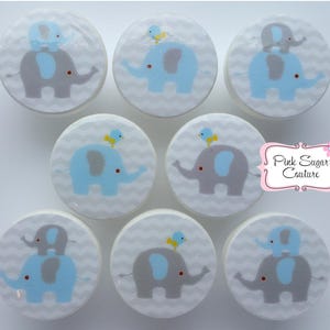 Peut inclure: Ensemble de 8 boutons de cabinet à thème éléphant et oiseau bleu et gris. Les boutons sont ronds et ont un fond blanc avec un motif en chevron. Les éléphants sont bleus avec des accents gris et les oiseaux sont jaunes. Le texte "Pink Sugar Couture" est visible en arrière-plan.