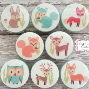 May include: Set of eight round wooden knobs with a light green background and various woodland animal illustrations. The animals include a fox, a deer, a squirrel, a rabbit, an owl, and a reindeer.