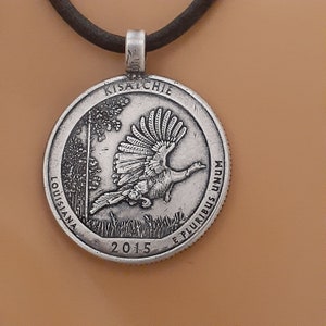 May include: Silver pendant necklace featuring a 2015 Kisatchie National Forest quarter with a wild turkey design. The inscription "E Pluribus Unum" and "Louisiana" are visible on the coin.