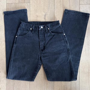 May include: Dark wash denim jeans with a classic five-pocket design. The jeans have a straight leg cut and a button and zipper closure. The jeans are made of a sturdy denim material and feature silver rivets.