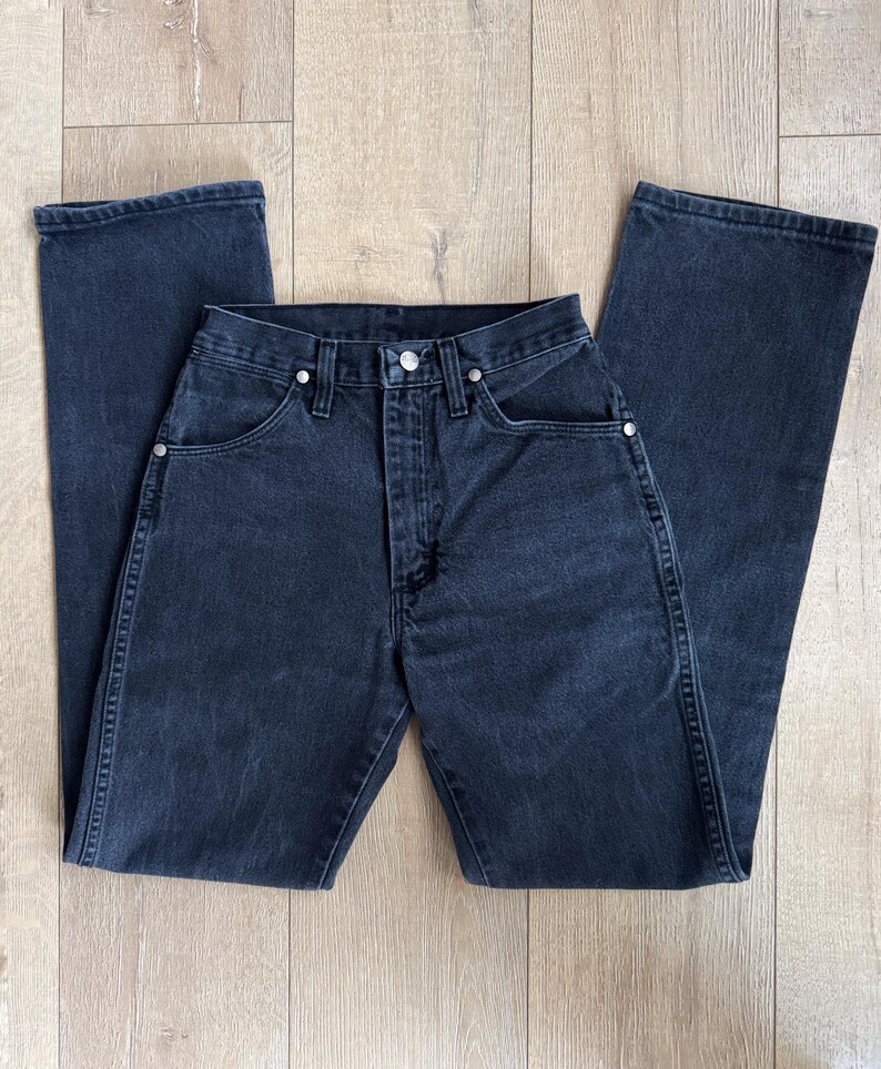 May include: Dark wash denim jeans with a classic five-pocket design. The jeans have a straight leg cut and a button and zipper closure. The jeans are made of a sturdy denim material and feature silver rivets.