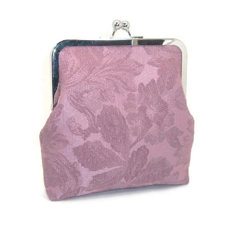 May include: A small, pink floral patterned purse with a silver clasp.