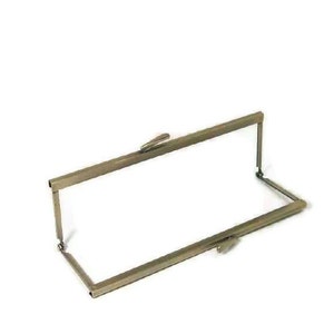 May include: A metal frame for a purse or wallet. The frame is made of a single piece of metal that is bent into a rectangular shape. The frame has a clasp on one side and a hook on the other side.