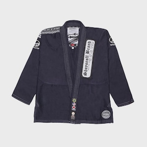 Pode incluir: Uniforme de artes marciais azul marinho com costuras brancas e vários patches. O uniforme apresenta o texto "Shoporoll Brand" e "The Art of Attack". O gi tem um padrão xadrez no ombro e vários patches circulares.