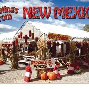 May include: A white tent with red chilli peppers hanging from the ceiling. There are also pumpkins and corn stalks on the ground. A sign reads "Red Chilli Powder 5. 2/lb."