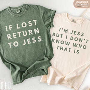 May include: Two Comfort Colors 1717 t-shirts, one moss green and one ivory. The moss green shirt reads "IF LOST RETURN TO JESS" in white block letters. The ivory shirt says "I'M JESS BUT I DON'T KNOW WHO THAT IS" in green letters.