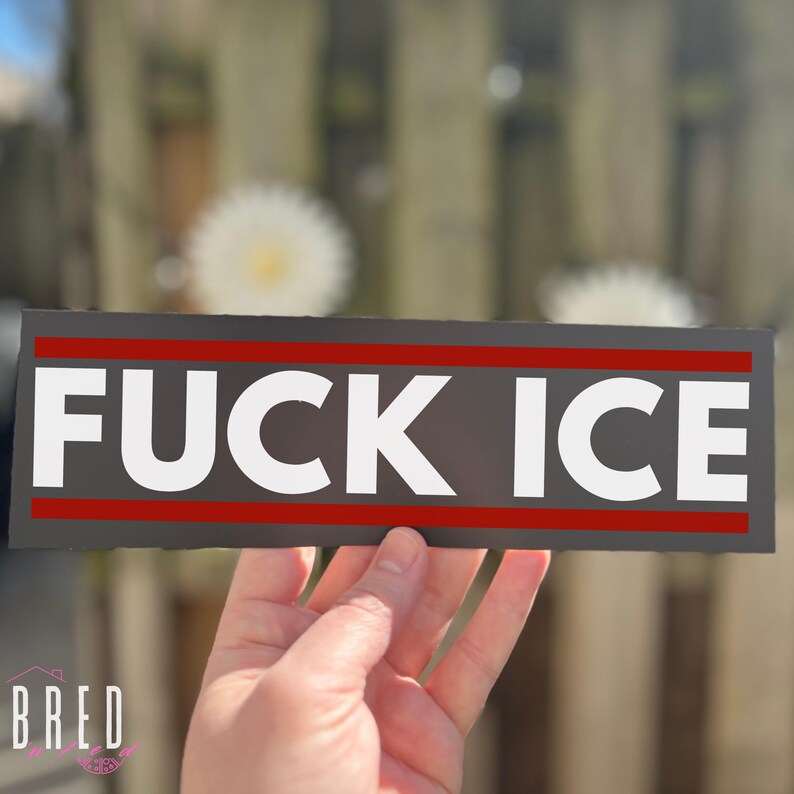 Hand holding a FUCK ICE car magnet, close-up view showing size and bold anti ICE protest message.