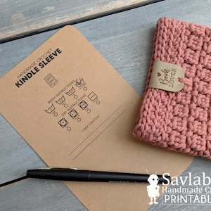 Peut inclure: Une étiquette d'entretien imprimable pour une housse Kindle faite à la main. L'étiquette est de couleur marron et présente une liste d'instructions de lavage et de séchage, ainsi qu'un espace pour la composition du tissu. Le texte "Handmade Crochet Kindle Sleeve" est en haut de l'étiquette.