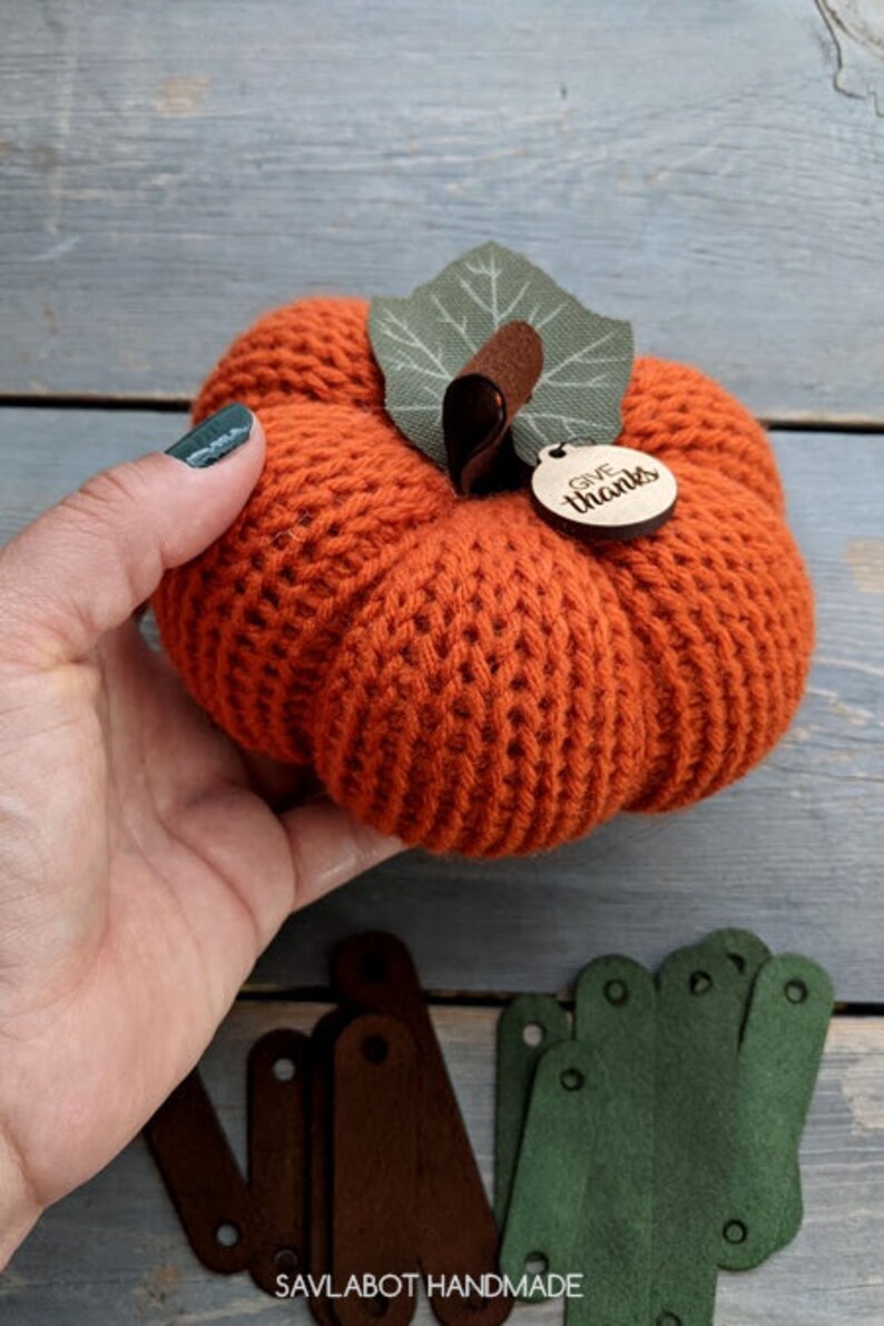 May include: A crocheted orange pumpkin with a green felt leaf and a wooden tag that says "Give Thanks".
