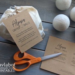Peut inclure: Un ensemble de quatre boules de séchage en laine d'alpaga blanches dans un sac en mousseline blanche avec une étiquette en papier brun qui indique "Boules de séchage en alpaga Ecologiques et hypoallergéniques Alternative naturelle aux feuilles de séchage Sans parfum synthétique et produits chimiques nocifs, les boules de séchage réduisent le temps de séchage et économisent de l'énergie FABRIQUÉES À LA MAIN AVEC DES FIBRES D'ALPAGA NATURELLES"