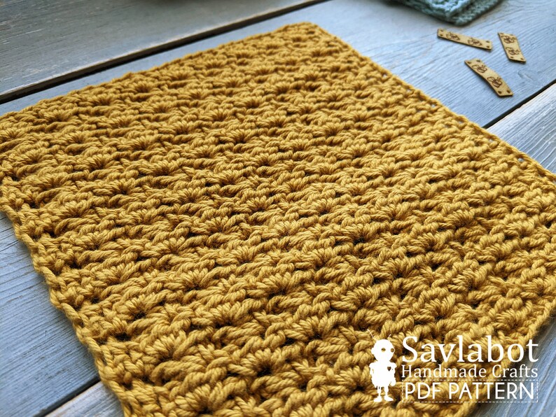 May include: A close-up of a crocheted square made with a mustard yellow yarn. The square is made with a textured stitch pattern. The image includes the text "Savlabot Handmade Crafts PDF Pattern".