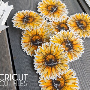 May include: A set of round, white gift tags featuring a watercolour sunflower design. The sunflowers are yellow and orange with brown centres. The tags have the word "Handmade" written in black script.