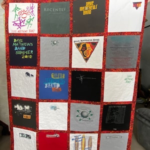 May include: A red and white quilt made from various Dave Matthews Band t-shirts. The quilt features a variety of designs, including the band's logo, tour dates, and album art. The quilt is a great way to show your love for the band.