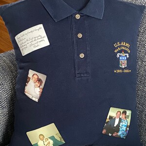 Peut inclure: Un oreiller bleu marine avec un logo brodé de l'U.S. Army War College sur le devant. L'oreiller a trois photos cousues dessus, deux d'un homme et d'une femme, et une d'un homme et d'un enfant. L'oreiller a une note manuscrite qui dit "Happy Father's Day my beautiful daughter Belama, think the Lord's everpleg of you and our daughter. Love and miss you, Dad."