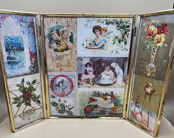 May include: A gold-framed tri-fold picture frame with a variety of vintage postcards. The postcards feature images of children, angels, flowers, and holiday greetings. The frame is a great way to display your favorite postcards or photos.